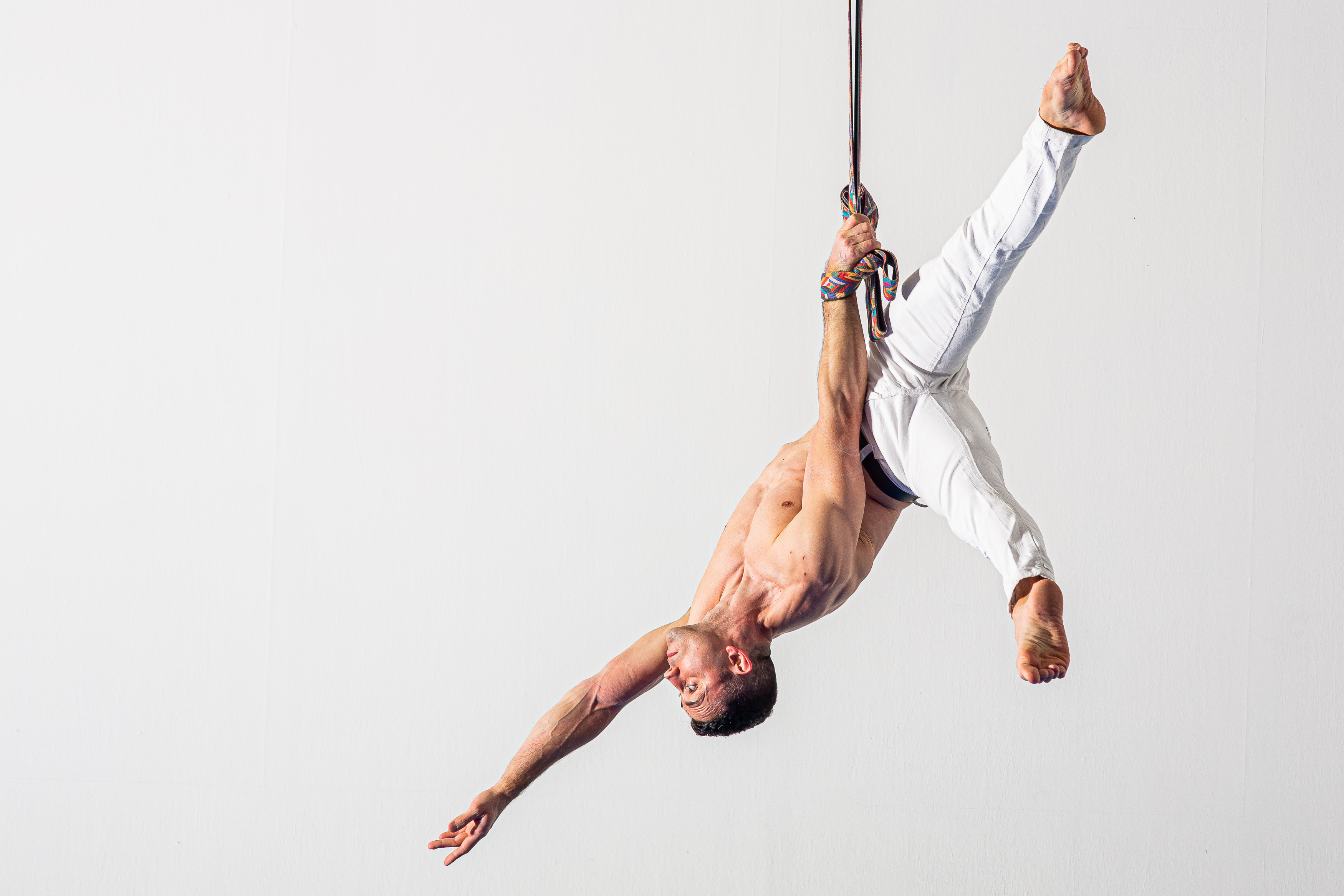 hanging by one arm in a meathook position